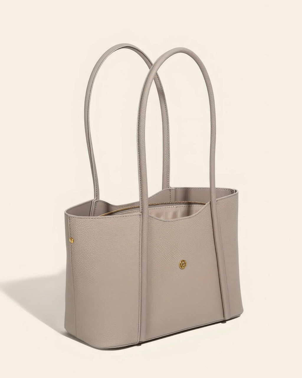 Side view of a grey genuine leather tote bag for women showing the pebbled texture and gold hardware.