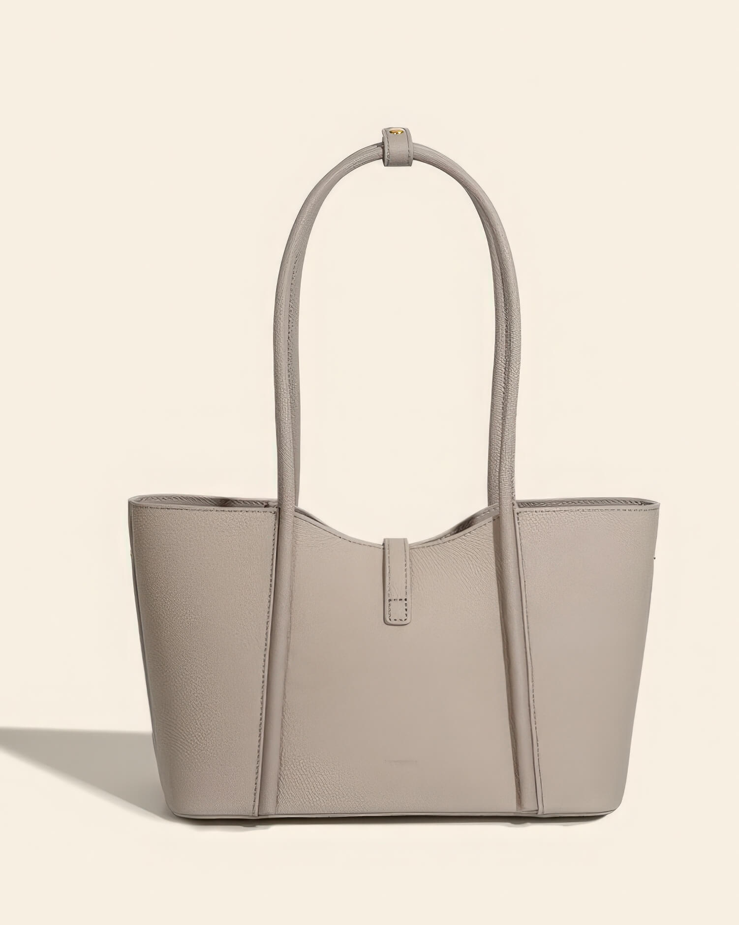 Back view of a minimalist grey leather tote bag with long handles and clean stitching.