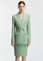 A front-facing, medium shot of the model wearing the mint green blazer, highlighting the double-breasted button detail, lapels, and pearl necklace.