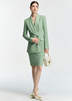 A full-body shot of the model posing with her hand on the blazer button, carrying a small cream-colored handbag that matches her white heels.