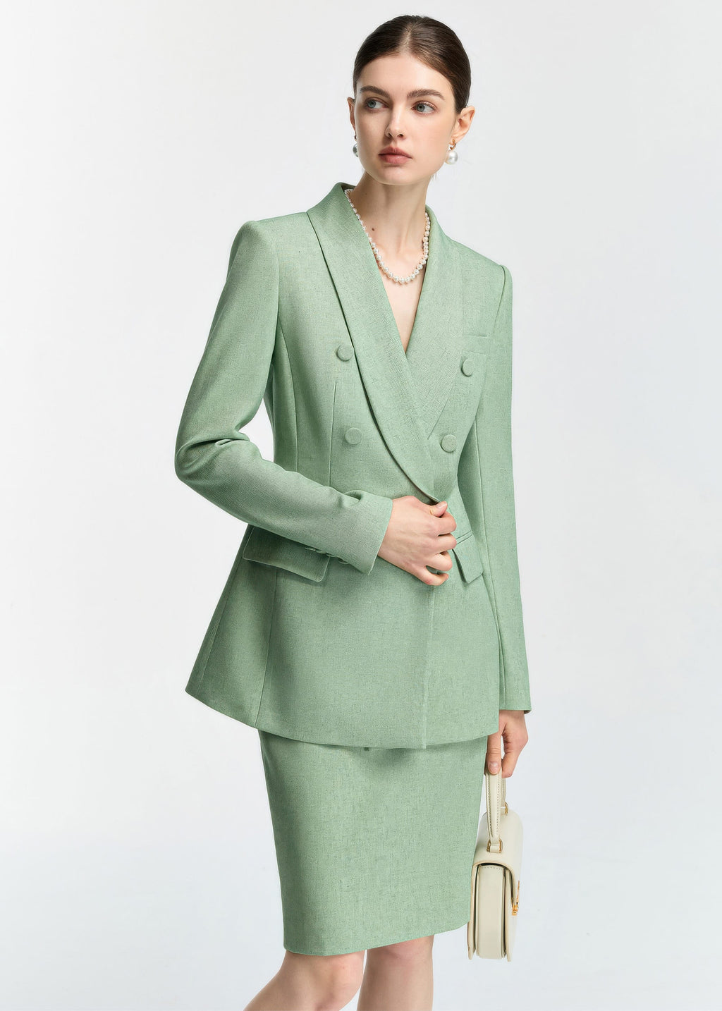 A close-up shot of the blazer's midsection and the model's hand, emphasizing the fabric texture and the flap pocket details.