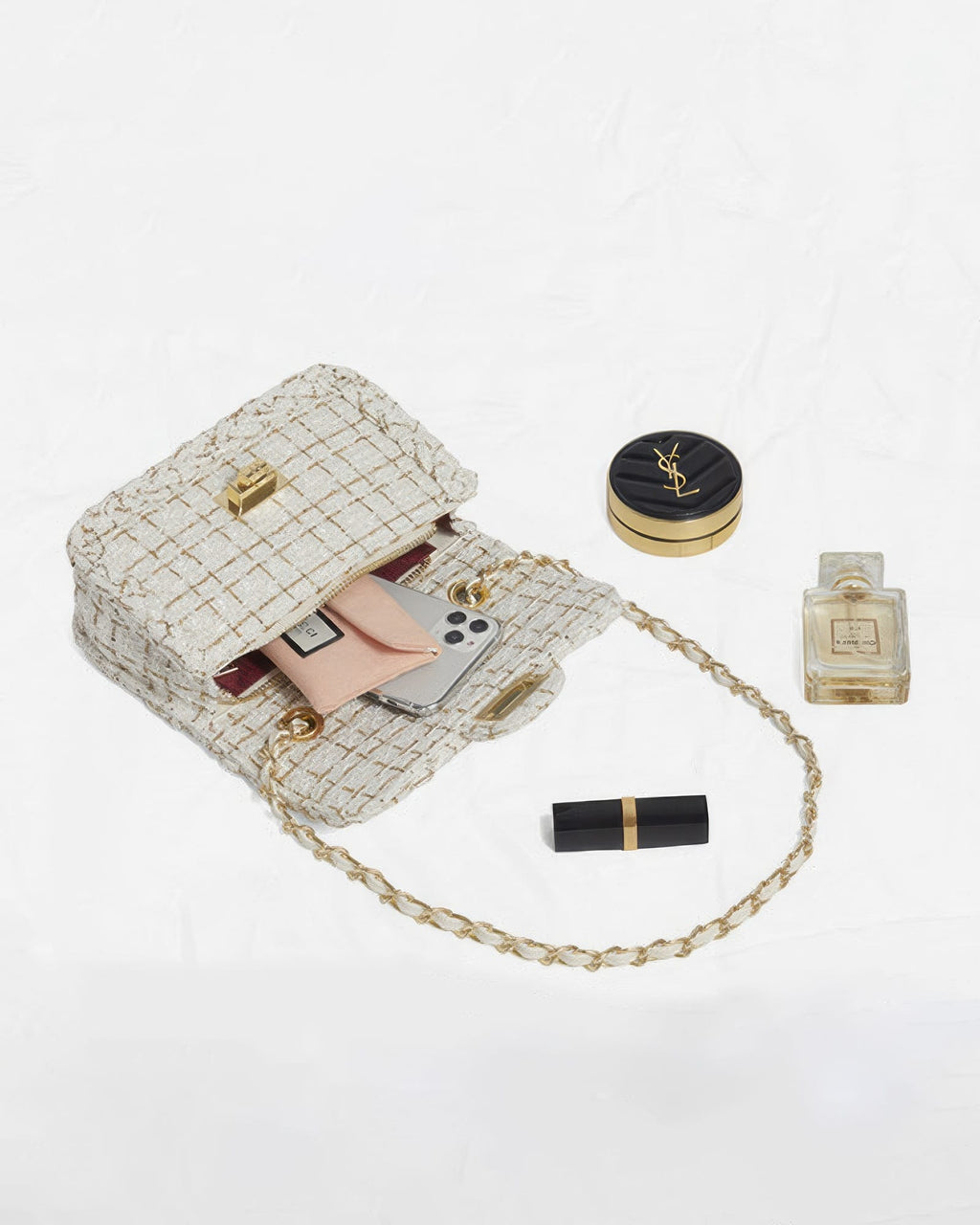 Open cream tweed flap purse displaying interior storage with smartphone card holder and beauty accessories