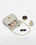 Open cream tweed flap purse displaying interior storage with smartphone card holder and beauty accessories