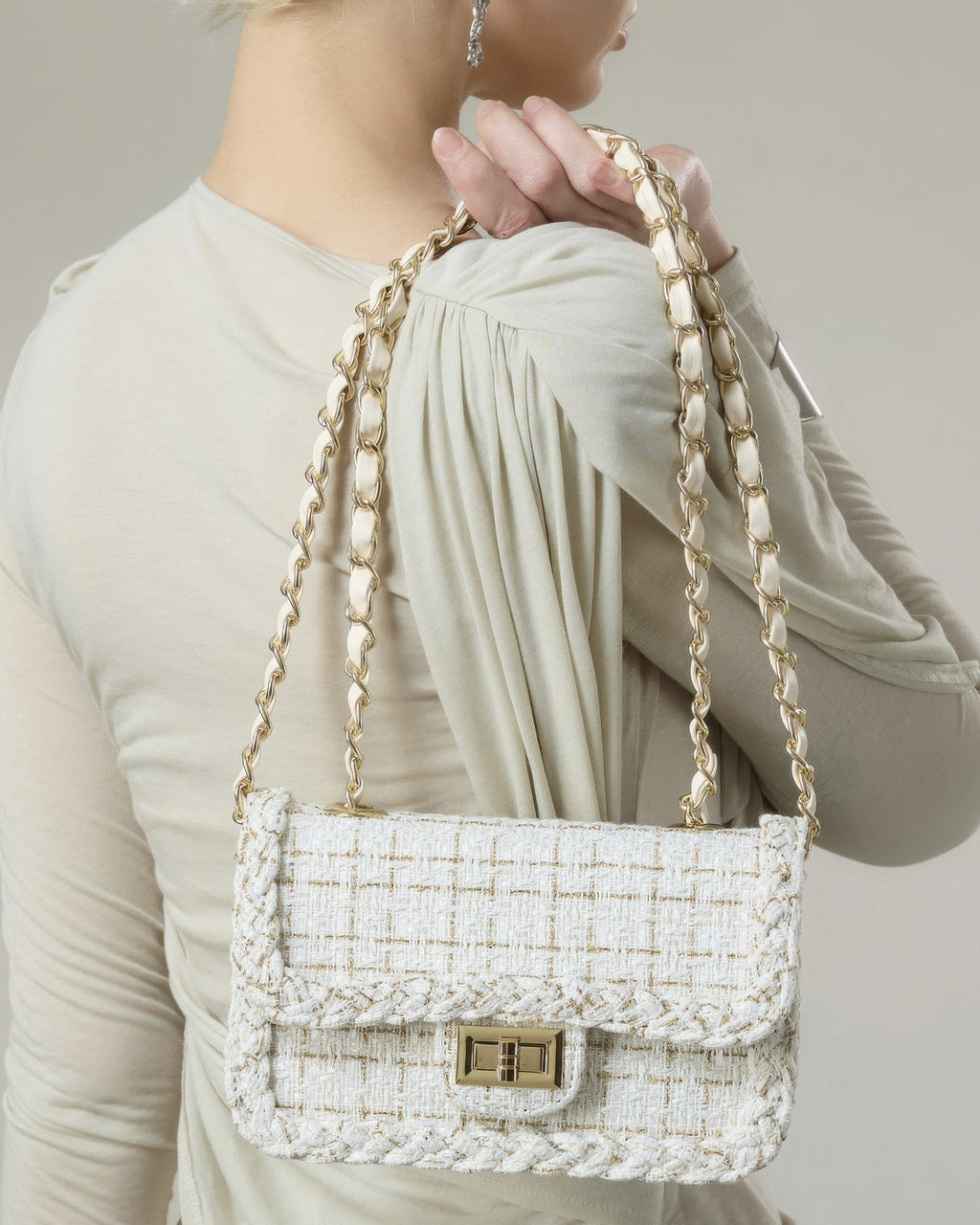 Back view of woman wearing cream woven tweed flap purse with double chain shoulder strap