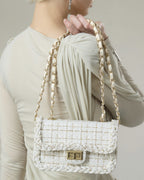 Back view of woman wearing cream woven tweed flap purse with double chain shoulder strap