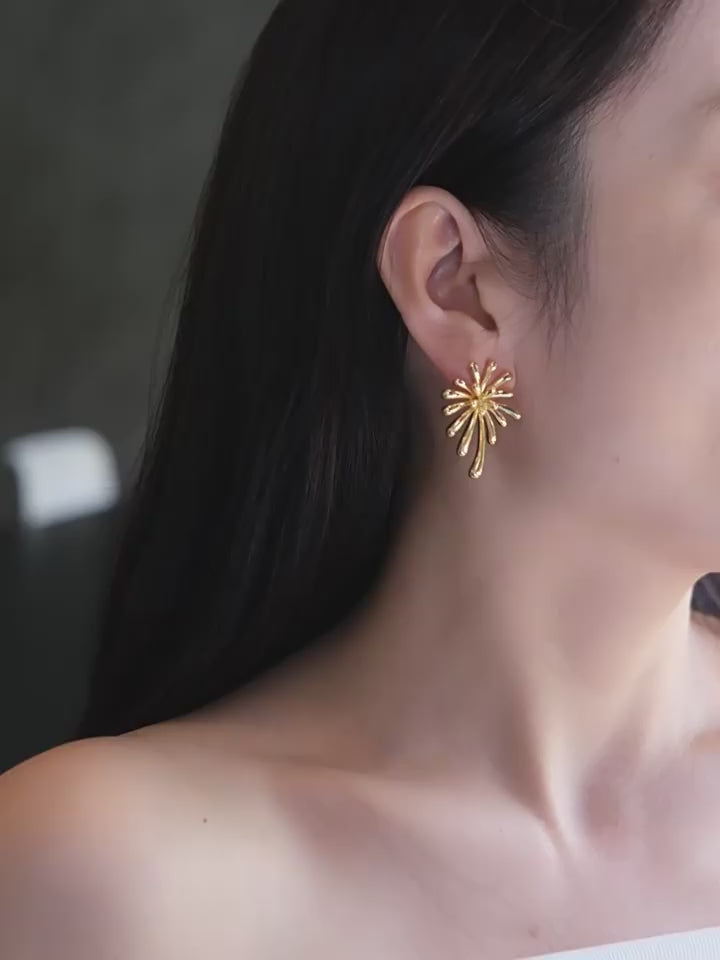Side view of a model wearing a Radiant 18K gold plated burst stud earring with a minimalist white outfit.