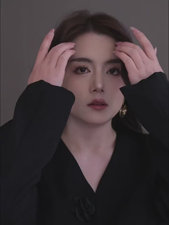 A video showcasing a pair of gold-toned concentric circle drop earrings. A model wears the earrings, tilting her head to show the light reflecting off the textured, spiral-etched surface and the modern vertical slit design.